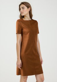 Braunes kurzes Kleid aus weichem, suedähnlichem Material, mit Rundhalsausschnitt und einer klaren, schlichten Silhouette, die am Saum leicht ausgestellt ist.