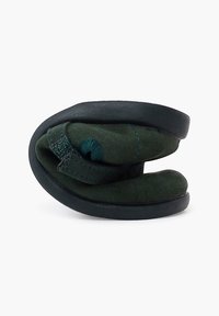 Zapatos de ante verdes con un diseño contorneado, que cuentan con una suela de goma negra y una forma plegada para un almacenamiento compacto.
