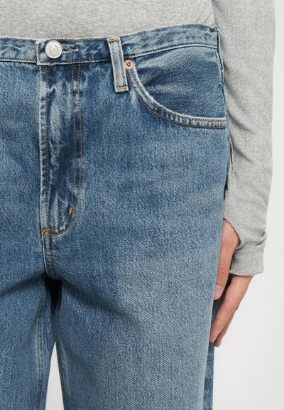 Light blue denim jeans with a high waist and five-pocket design. Features copper-tone hardware and subtle fading on the thighs.
