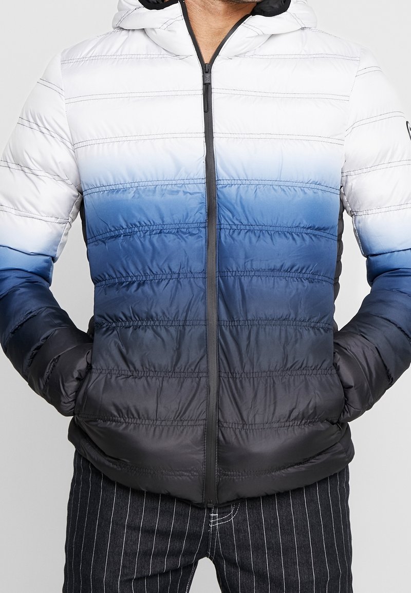 Gevoerde hooded jack met een gradientontwerp: wit naar donkerblauw. Geleide strepen met een rits aan de voorkant en twee zijzakken.