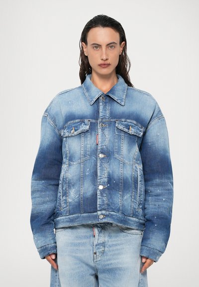 Jachetă din denim cu un degrade de la albastru deschis la albastru închis, detalii uzate, două buzunare la piept și nasturi argintii. Asortată cu blugi în aceeași nuanță.