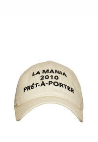 Beige színű baseball sapka, pamutból készült, fekete hímzett szöveggel: "LA MANIA 2010 PRÊT-À-PORTER." Ívelt napernyővel és fém szemjelezéssel rendelkezik.