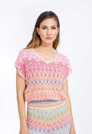 Knitted top in pink, orange, and blue gradient with a chevron pattern. Loose fit, V-neck, and short sleeves. Soft, textured fabric.
