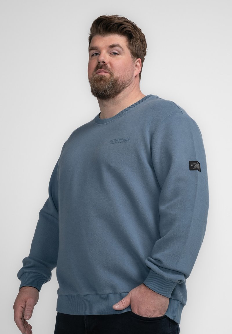 Lichtblauwe sweatshirt gemaakt van een katoenmix, met ribgebreide manchetten, ronde halslijn en een klein logo-opkleefsel op de linker mouw.