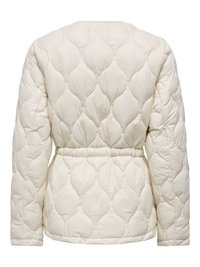 Veste matelassée couleur crème à manches longues avec taille cintrée, présentant un motif ondulé cousu sur tout le tissu.