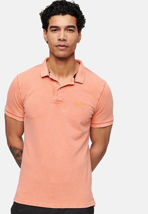 Polo shirt pesca con maniche corte, colletto e tre bottoni. Presenta un logo ricamato, tessuto di cotone e una vestibilità comoda.