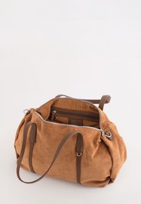 Brun suede taske med læderhåndtag, delvist �åben lynlås der viser stribet indvendig foring og en indvendig lynlås lomme.