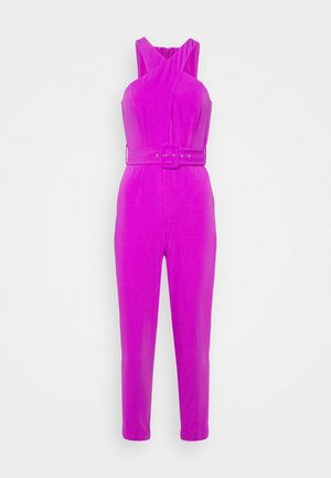 Lyserød ærmeløs jumpsuit med krydset halsudskæring og matchende bælte i taljen på ensfarvet hvid baggrund.
