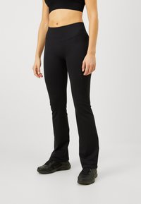 Leggings negros con una cinturilla ancha y acanalada, de corte ajustado a lo largo de las piernas, fabricados en un material elástico para mayor comodidad y libertad de movimiento.