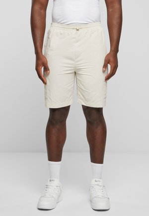 Lys beige shorts med elastisk talje og snor, med sidelommer og en glat, let stofstruktur.