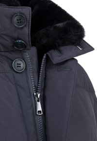 Granatowa ocieplana kurtka z kołnierzem wykończonym sztucznym futrem, zapięcie na zamek błyskawiczny oraz cztery guziki. Posiada gładki materiał i starannie uszyte detale.