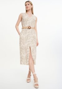 Beige ärmelloses Kleid mit V-Ausschnitt und Zebramuster, versehen mit einem hohen Schlitz bis zum Oberschenkel und einem gewebten Gürtel in der Taille.