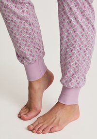 Lichtpaarse pyjamabroek met een bloemenpaisleypatroon, geribbelde boorden bij de enkels en een zachte katoenstructuur.
