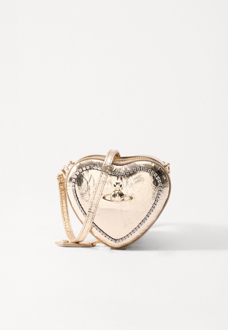 Sac à main en forme de cœur en métal or avec une texture lisse. Présente une bordure embellie de cristaux et une fine bandoulière pour le porter.