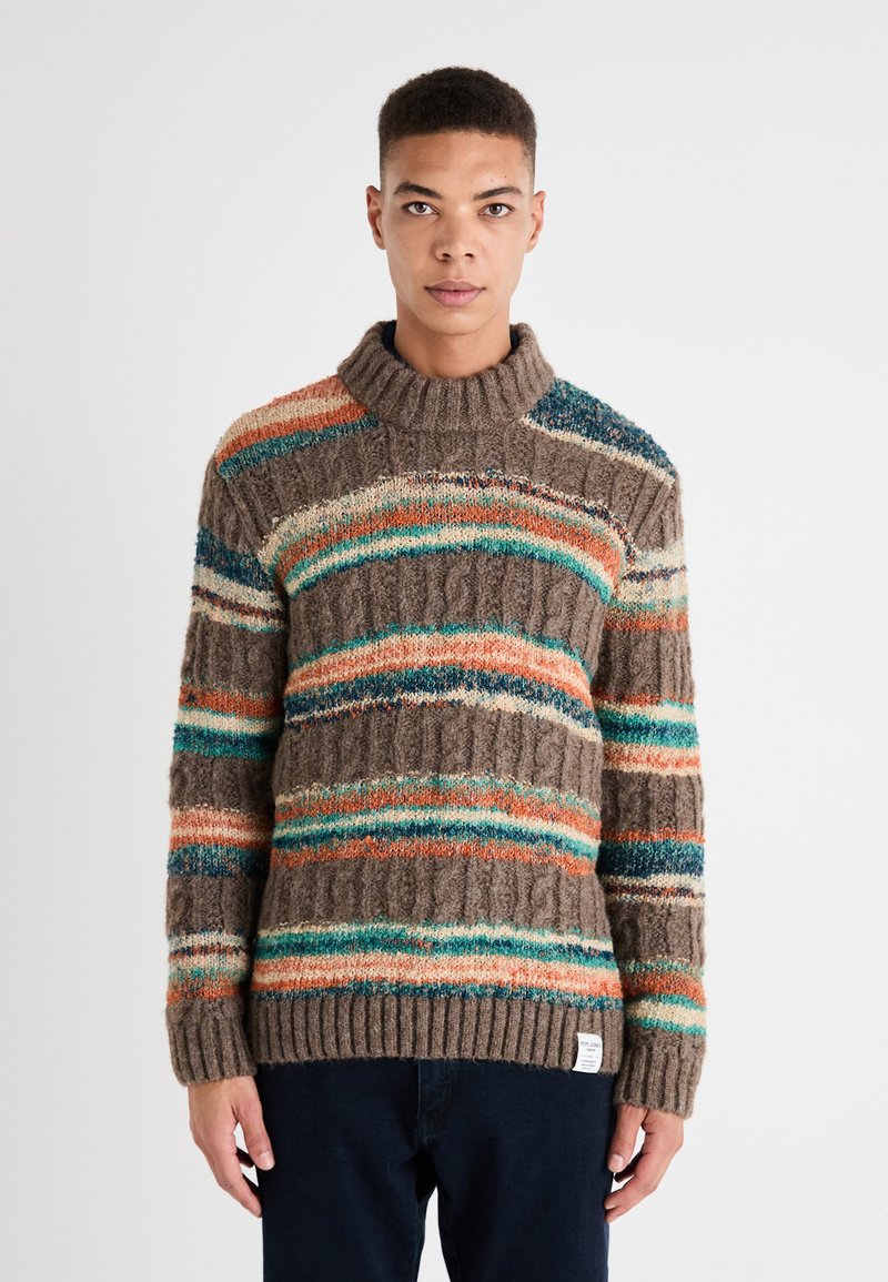 Suéter de punto en marrón con rayas multicolores en naranja, azul verdoso y crema. Cuenta con un cuello alto y puños y dobladillo de canalé. Patrón texturizado.