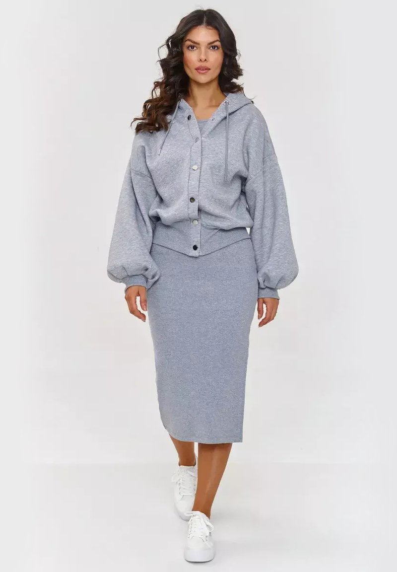 Szary hoodie z guzikami i sznurkiem, w zestawie z dopasowaną, midi spódnicą. Teksturowany materiał i luźny krój, z białymi sneakersami.