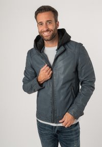 Blauwe leren jas met een grijze hoodie voering, ritssluiting en zijzakken. De jas heeft een zachte textuur en een getailleerde pasvorm.