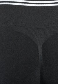 Svarta leggings med en slät yta och en åtsittande design. Midjebandet har två vita horisontella ränder för extra detalj.