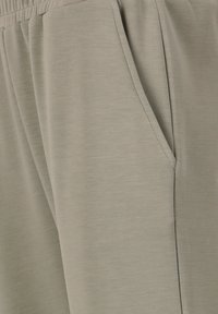 Ljusgråa sweatpants med mjukt, strukturerat tyg, elastisk midja och sidofickor för praktisk användning.