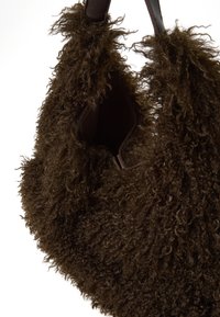 Borsa a tracolla marrone con materiale riccio e shaggy. Apertura superiore con rivestimento interno morbido. Presenta manici in pelle resistenti.