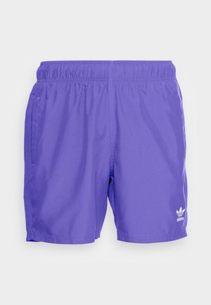Fioletowe sportowe szorty Adidas z elastycznym pasem i kieszeniami po bokach, z logo Adidas trefoil na lewej nogawce.