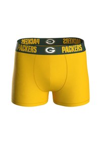 Calzoncillos boxers amarillos con una cinturilla verde que presenta la palabra “PACKERS” y un logo. La tela tiene una textura suave y elástica.