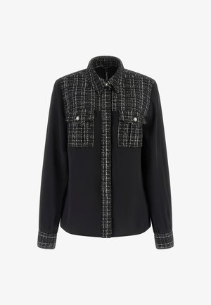 Black shirt with a textured black and white check-patterned front, snap closure, and two chest pockets, featuring long sleeves and soft fabric.