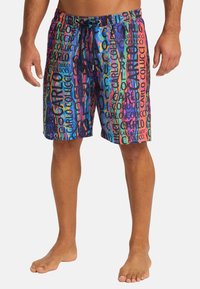 Multicolored swim shorts featuring a bold graphic pattern with text. Made from lightweight material, they have an elastic waistband and drawstring.