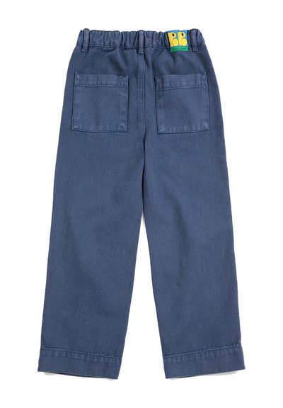Pantalon bleu droit avec ceinture élastique, deux poches plaquées à l'arrière et une petite étiquette colorée avec logo près de la ceinture.