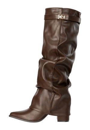 Botte en cuir marron haute et souple avec un petit talon bloc et une sangle décorative avec boucle dorée près du sommet.