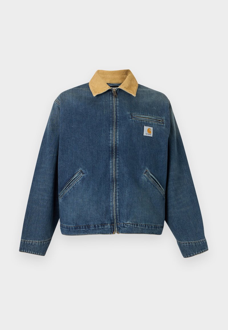 Giacca di denim con colletto in velluto a coste beige, zip frontale, due tasche per le mani e tasca sul petto con toppa del logo Carhartt.