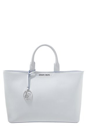 Sac cabas en cuir blanc avec deux poignées, logo Armani Jeans sur le devant, et un charm métallique circulaire suspendu à une poignée.