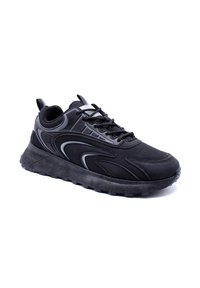 Chaussure de sport noire avec une tige en mesh, une semelle en caoutchouc, un bout arrondi et des accents texturés. Elle est dotée de lacets et d'un col rembourré pour plus de confort.