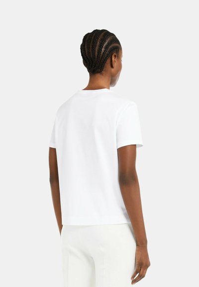 T-shirt bianco in cotone con maniche corte e collo rotondo. Tessuto morbido e vestibilità comoda. La parte posteriore presenta un design semplice senza motivi.