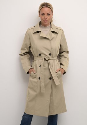 Béžový trench coat s dvojitými gombíkmi, opasok v páse, veľké bočné vrecká a štruktúrovaný golier, vyrobený z hladkej tkaniny.