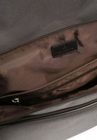 Interno di una borsa grigia texture con una fodera marrone liscia, dotato di tasca con zip e un'etichetta in pelle con marchio.