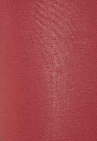 Röd texturerad tyg med en subtil glans, med fin ribbning och en slät yta. Idealisk för plagg som kräver elasticitet och komfort.