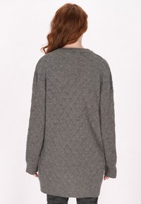 Maglione grigio a maglia con motivo a rombo, maniche lunghe e vestibilità rilassata, con parte posteriore più lunga e polsini a coste.