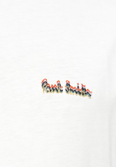 T-shirt bianca in cotone con testo ricamato multicolore "Paul Smith" in uno stile ondulato e corsivo, con fili rossi, blu e oro.