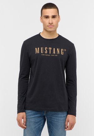Langärmliges schwarzes T-Shirt aus Baumwolle mit einem auffälligen goldenen "MUSTANG"-Logo auf der Brust und einem klassischen Rundhalsausschnitt.