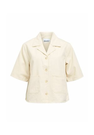 Veste beige à manches courtes avec boutons, deux poches devant et un col, étiquetée ".OBJECT" à l'intérieur de l'encolure.