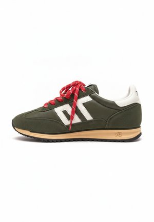 Zapatilla deportiva verde oscuro con tacón y logo blanco, cordones rojos, suela beige con marca "70" y banda de rodadura negra, mostrada de lado sobre fondo blanco.