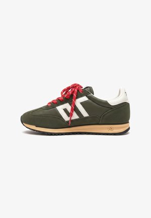 Zapatilla deportiva verde oscuro con tacón y logo blanco, cordones rojos, suela beige con marca "70" y banda de rodadura negra, mostrada de lado sobre fondo blanco.