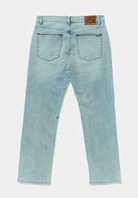 Jeans de mezclilla azul claro extendidos, mostrando la vista trasera con dos bolsillos y una etiqueta de marca marrón en la cintura.