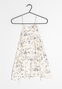 Lehký krémový top na ramínka s tenkými pásky a nařasenými detaily. Vlastnosti zahrnují námořnický skicový vzor krajin a palem.