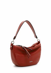 Sarkana ādas rokassoma ar izliektu formu, īsu rokturi, rāvējslēdzēja aizdari un dekoratīviem bārkstīm. Zīmola logotips redzams sānos.