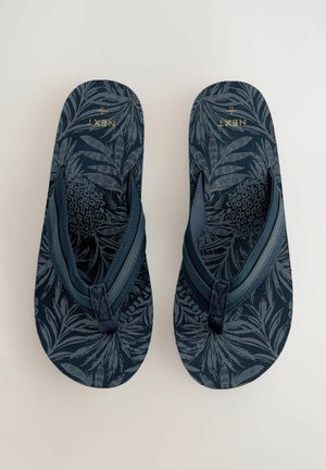 Marine flip-flops med en tekstureret sål med et bladmønster. Stropperne er mørkeblå med syningsdetaljer. Guldlogo synligt.
