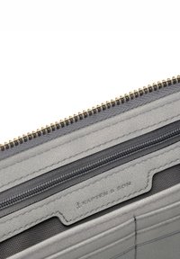 Grå läderplånbok med strukturerad yta, med en guldfärgad dragkedja och en liten ficka med mörk foder. Märkesetiketten är präglad.