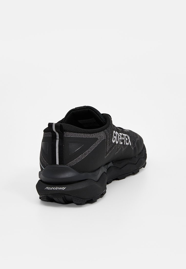 Czarne buty sportowe z teksturowaną siateczkową cholewką, z logo Gore-Tex oraz masywną gumową podeszwą z zygzakowatym bieżnikiem.