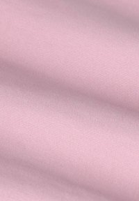 Tissu rose clair avec une texture lisse et un subtil motif de côtes, affichant une couleur uniforme et une douceur constante. Pas de quincaillerie ou d'accents visibles.